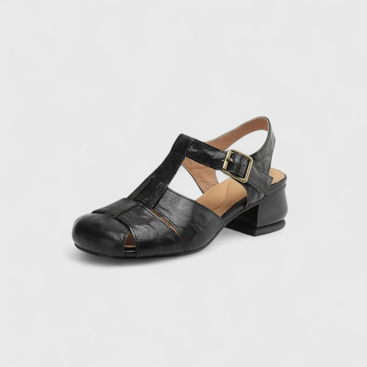 Black closed-toe sandals with a slim T-strap, buckled slingback and a low block heel.