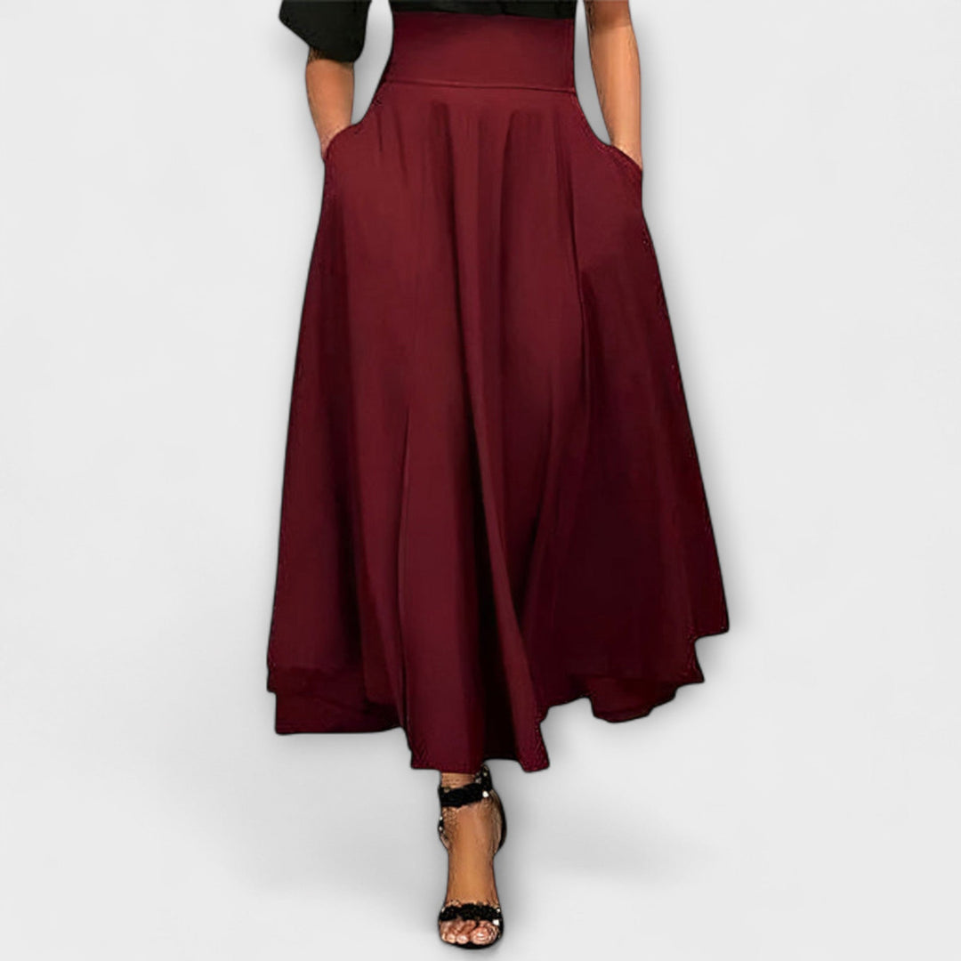 A woman in a flowing elegant maxi skirt styled with a simple top for a confident, striking look.