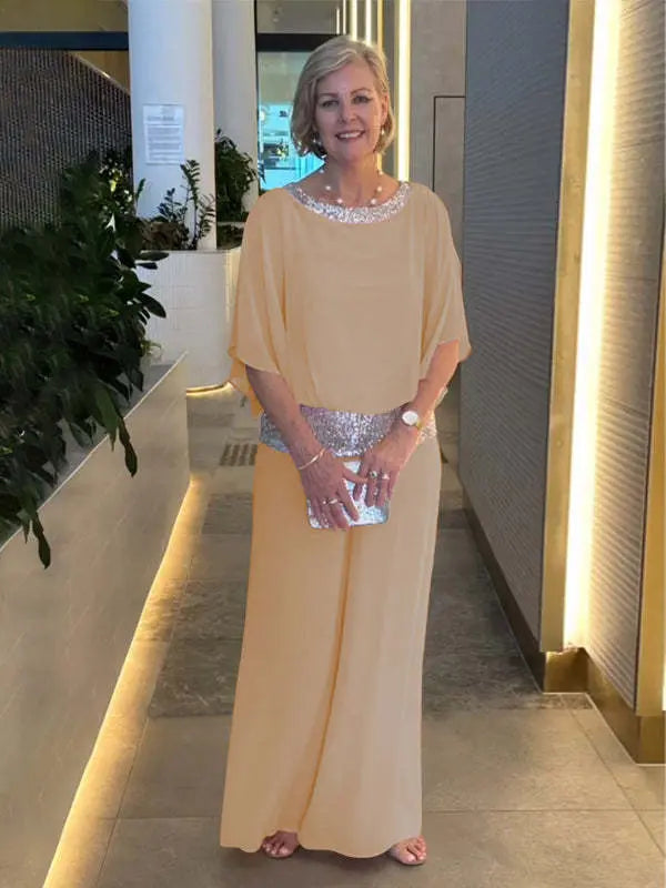 A woman wearing an embellished blouse-style top with softly flowing wide evening pants.