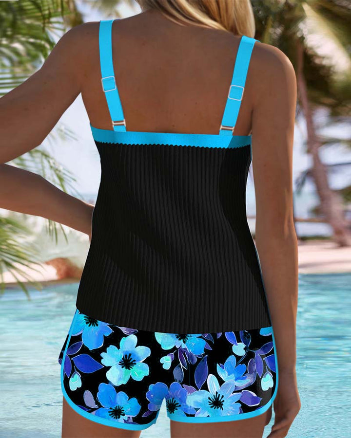 A woman at the water's edge in a bright printed two-piece tankini, relaxed and confident.