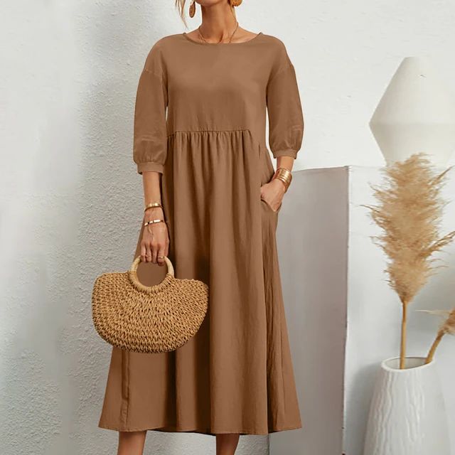 A woman wearing the Barbara fitted waist midi dress with three-quarter sleeves and a flowing skirt.