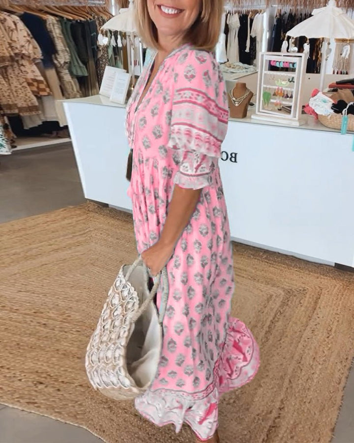A woman wearing the Tracy boho floral midi dress with a fringed neckline and ruffled skirt.