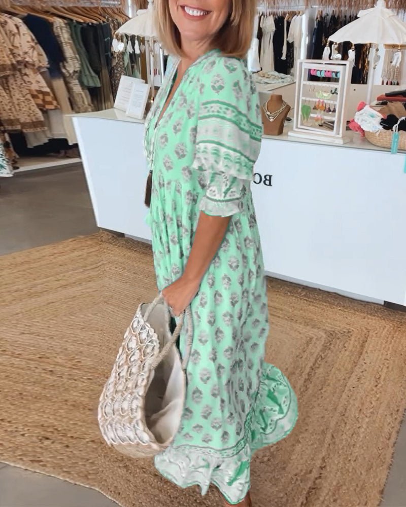 A woman wearing the Tracy boho floral midi dress with a fringed neckline and ruffled skirt.