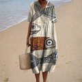 A woman wearing a flowing printed dress that moves softly around her at a warm summer gathering.