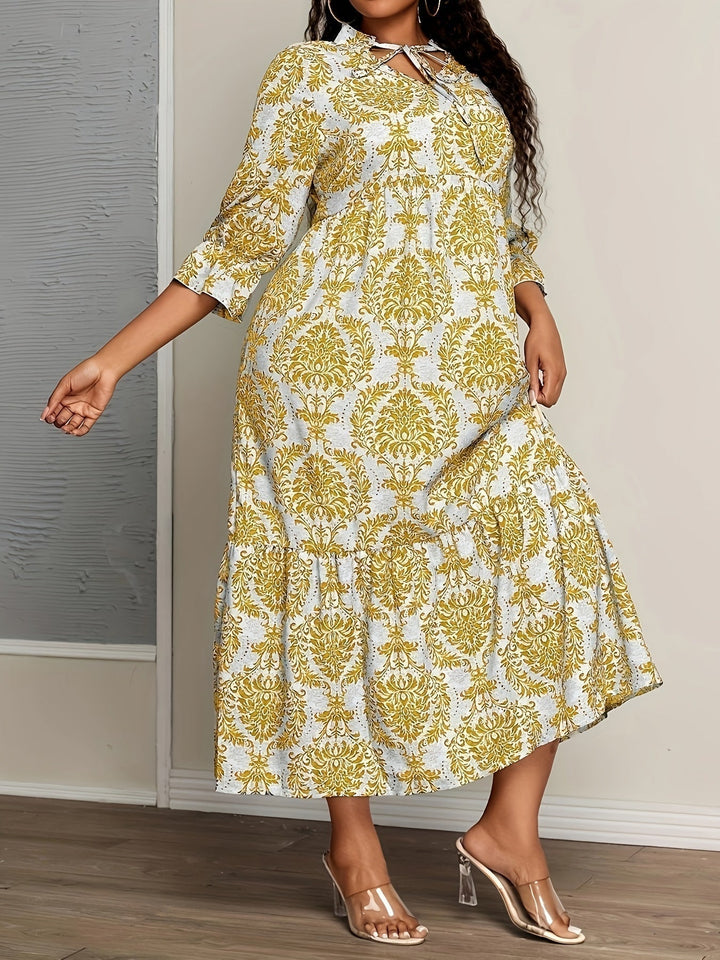 Woman strolling by the sea in the Melanie mosaic print maxi dress with a keyhole neckline and bow detail.