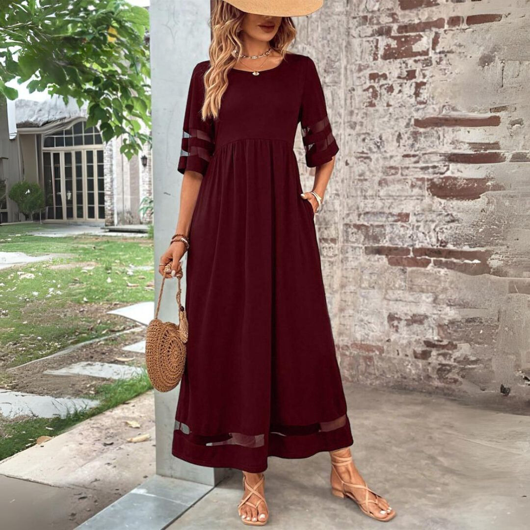 Woman wearing the Colleen™ empire waist midi dress with a flowing skirt and round neckline at a family gathering.