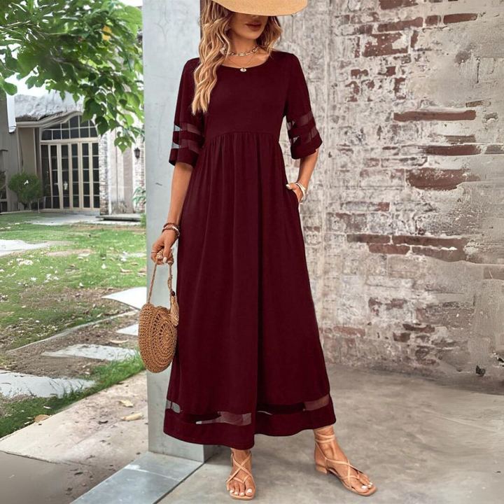 Woman wearing the Colleen™ empire waist midi dress with a flowing skirt and round neckline at a family gathering.