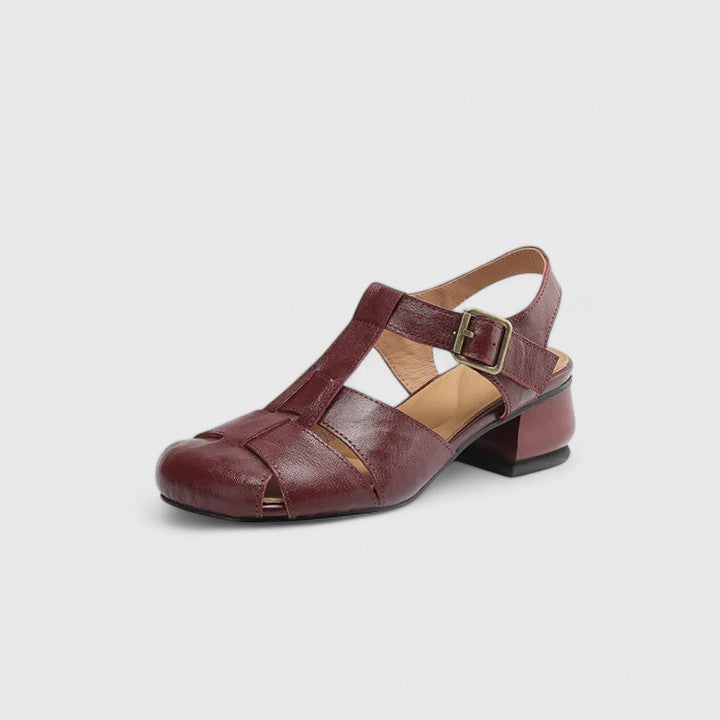 Black closed-toe sandals with a slim T-strap, buckled slingback and a low block heel.
