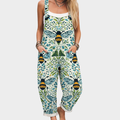 A woman wearing relaxed bee-and-vine print overalls with adjustable straps on a warm day.