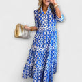 A woman wearing a flowing chain print midi dress that drapes elegantly as she walks.