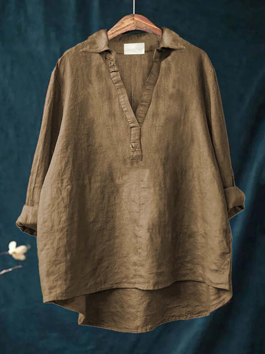 A woman wearing an elegant solid-colour summer blouse with an open V-neck, looking fresh and stylish on a warm day.