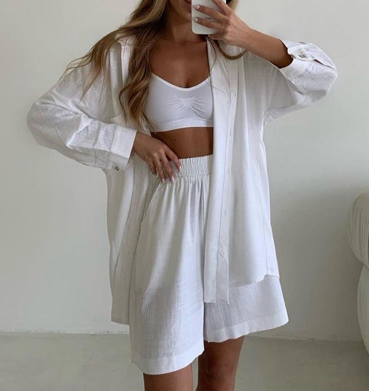 A woman wearing an oversized button-up shirt with matching high-waisted shorts.