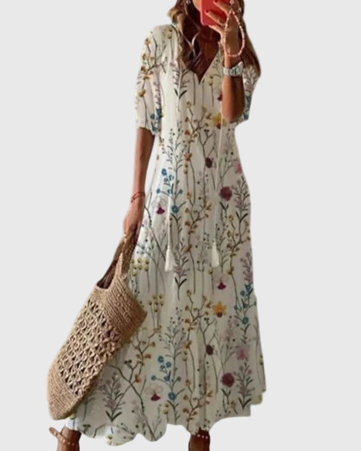 Woman wearing a long vintage-style boho maxi dress with delicate patterns and a fluttering V-neckline.