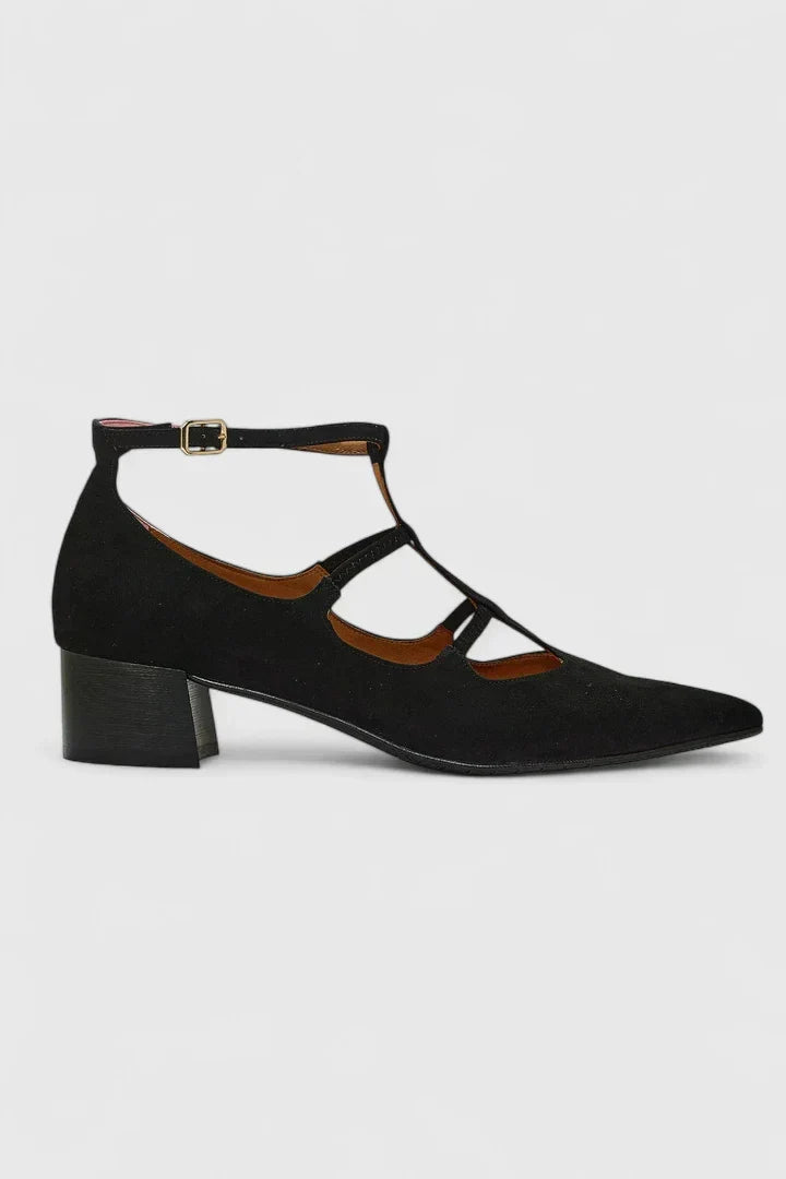 A woman standing gracefully in low wide-fit comfort heels with a cushioned footbed.