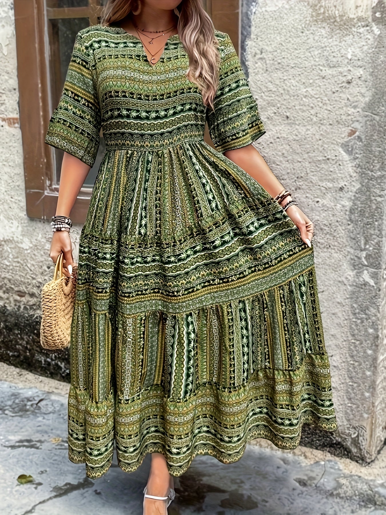Woman wearing a flowing bohemian maxi dress with intricate pattern and ruffled details.