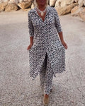 A woman wearing a black-and-white geometric-print longline top with matching pants, standing outdoors.