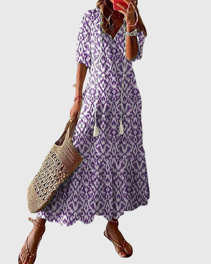 Woman wearing a long vintage-style boho maxi dress with delicate patterns and a fluttering V-neckline.