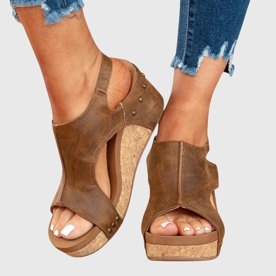 A woman in taupe wedge sandals with an open front, out shopping on a warm day.