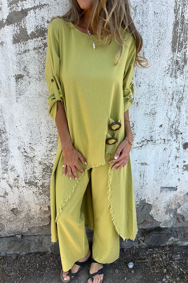 A woman wearing a flowing draped two-piece set with an asymmetric hem, relaxed and elegant.
