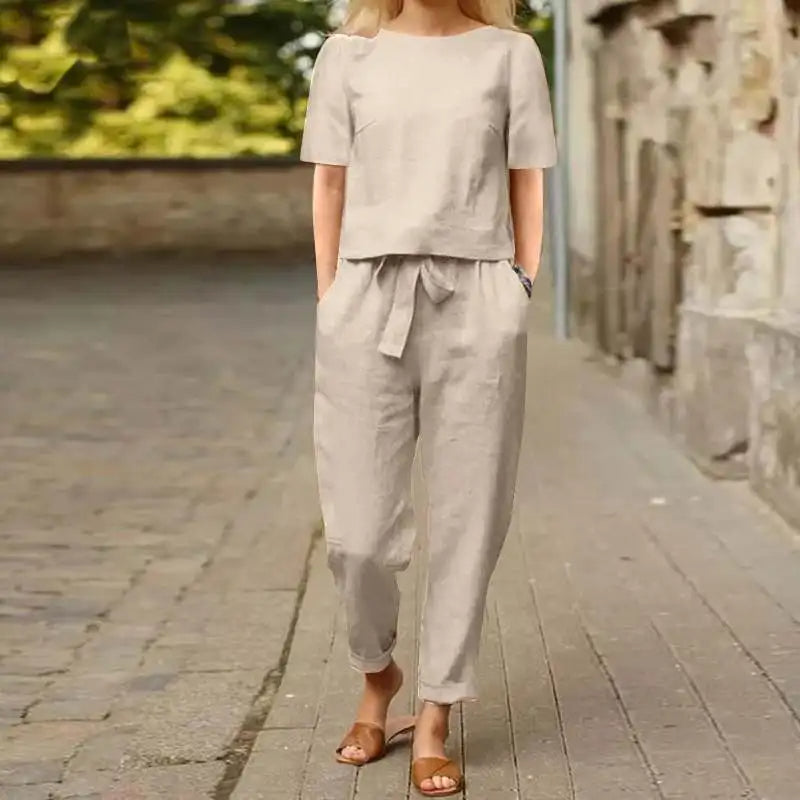 A woman wearing a relaxed short-sleeve top and matching drawstring pants lounge set.