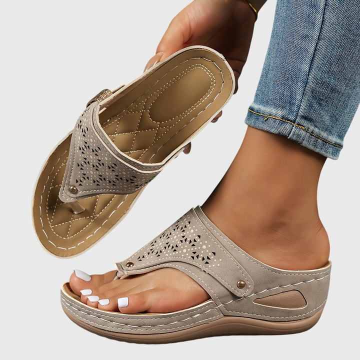 A woman in grey comfort flip-flops relaxing outdoors, feet cushioned and supported.