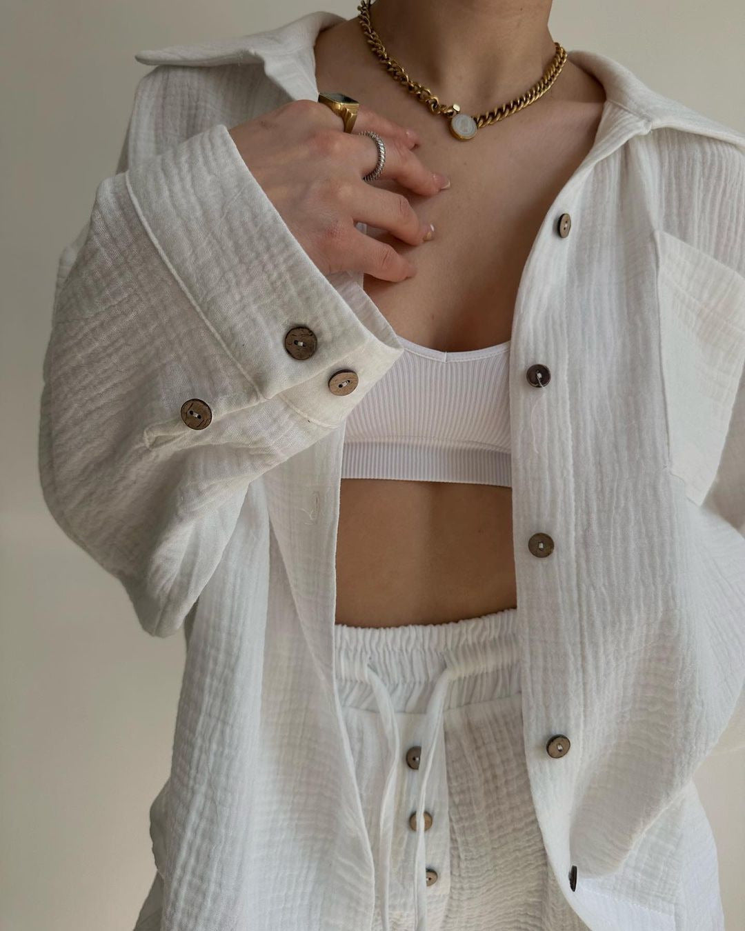 A woman wearing a flowing oversized shirt with drawstring shorts, relaxed and breezy.