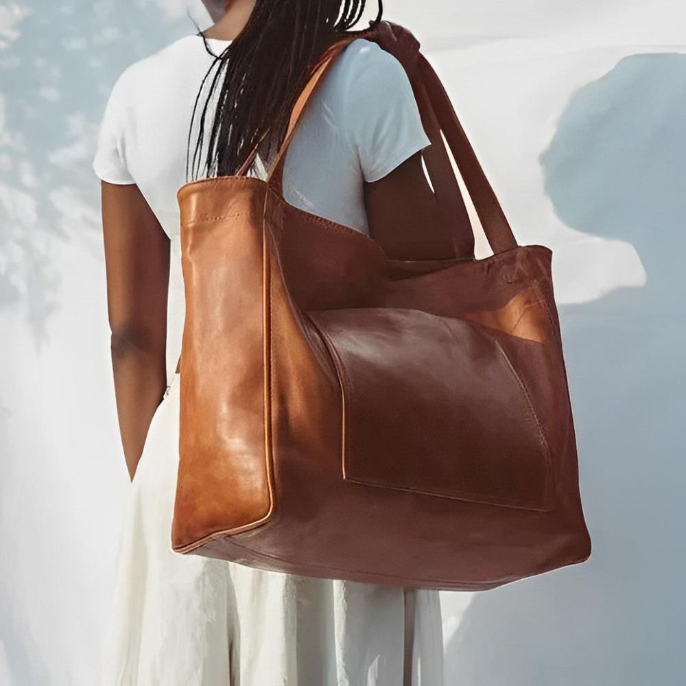 A woman wearing a vintage-style shoulder bag while walking through a weekend market.