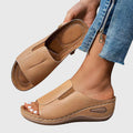 Tan open-toe wedge slides with a smooth one-piece upper and a cushioned wedge sole.