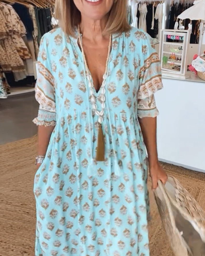 A woman wearing the Tracy boho floral midi dress with a fringed neckline and ruffled skirt.