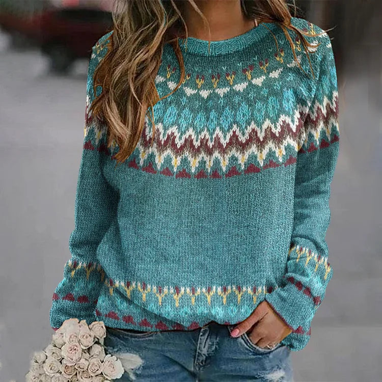 A woman wearing a teal sweater with a colourful retro zigzag pattern and a round neck, relaxed and cosy for fall.