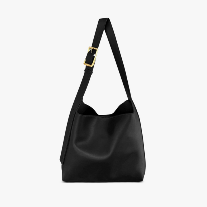 A tan bucket-style shoulder bag with an adjustable buckled strap