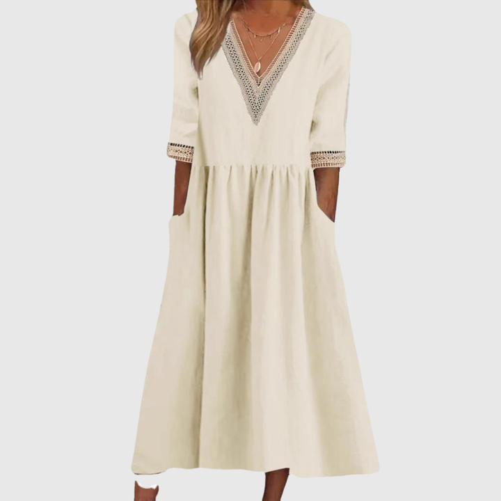 A woman wearing the Anne V-neck midi dress with delicate detailing at the collar and sleeves.