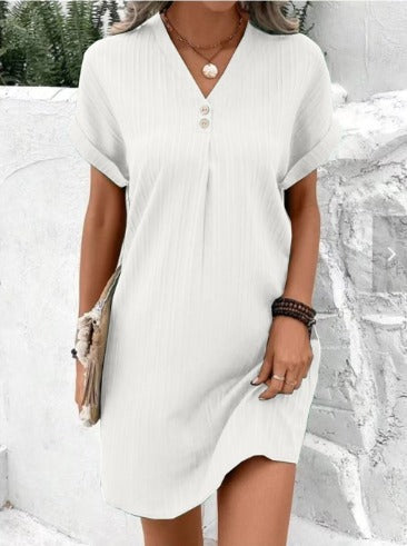 Woman wearing the Cheryl layered V-neck dress, relaxed and smiling at a spring lunch with friends.
