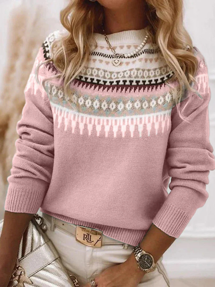 A woman wearing a soft powder-blue sweater with a cream, tan and black Nordic yoke pattern