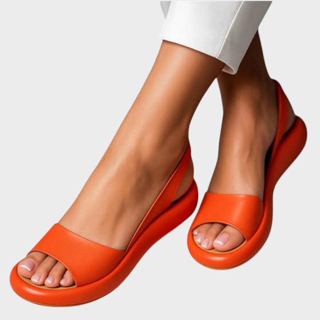 A woman walking gracefully in lightweight orthopaedic sandals with an adjustable strap on a sunny day.