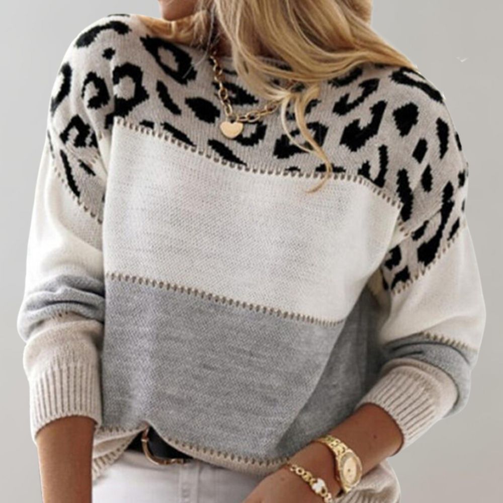 A woman wearing a grey leopard-print sweater, cosy and stylish, paired with jeans.