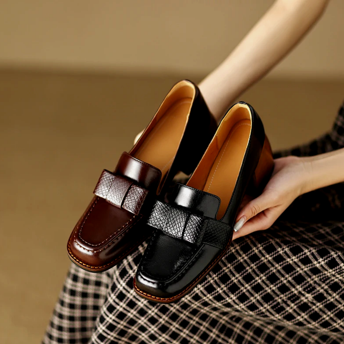 A woman wearing classic loafers with a subtle knot detail and tailored pants