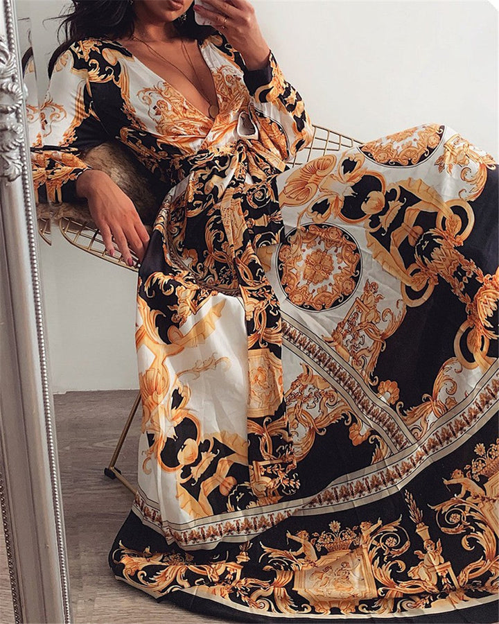 Woman at golden hour wearing the Eileen vintage print maxi dress with a waist belt and long statement sleeves.