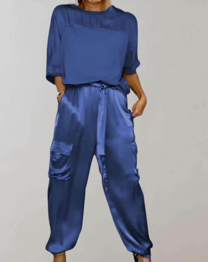A woman wearing a silky-finish cargo top and pants lounge set with pockets.