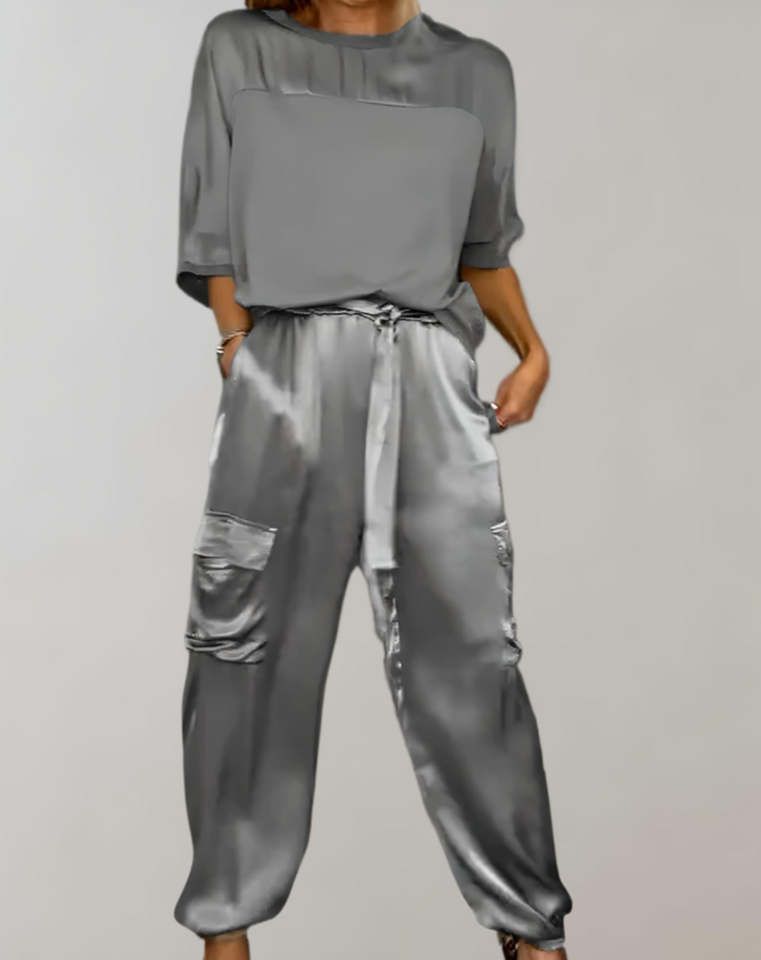 A woman wearing a silky-finish cargo top and pants lounge set with pockets.