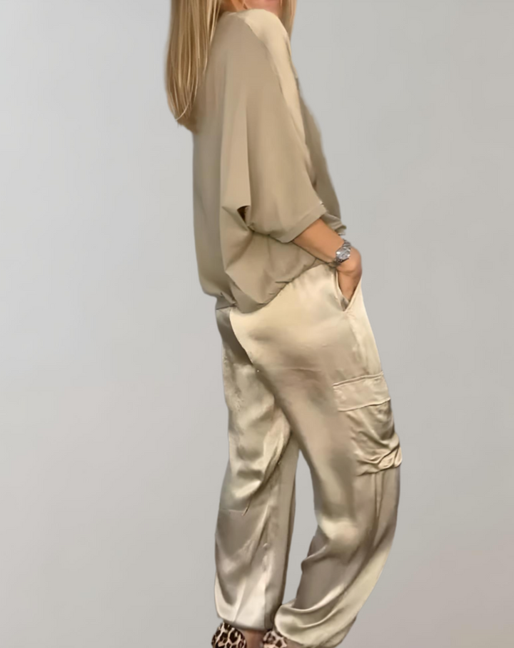A woman wearing a silky-finish cargo top and pants lounge set with pockets.