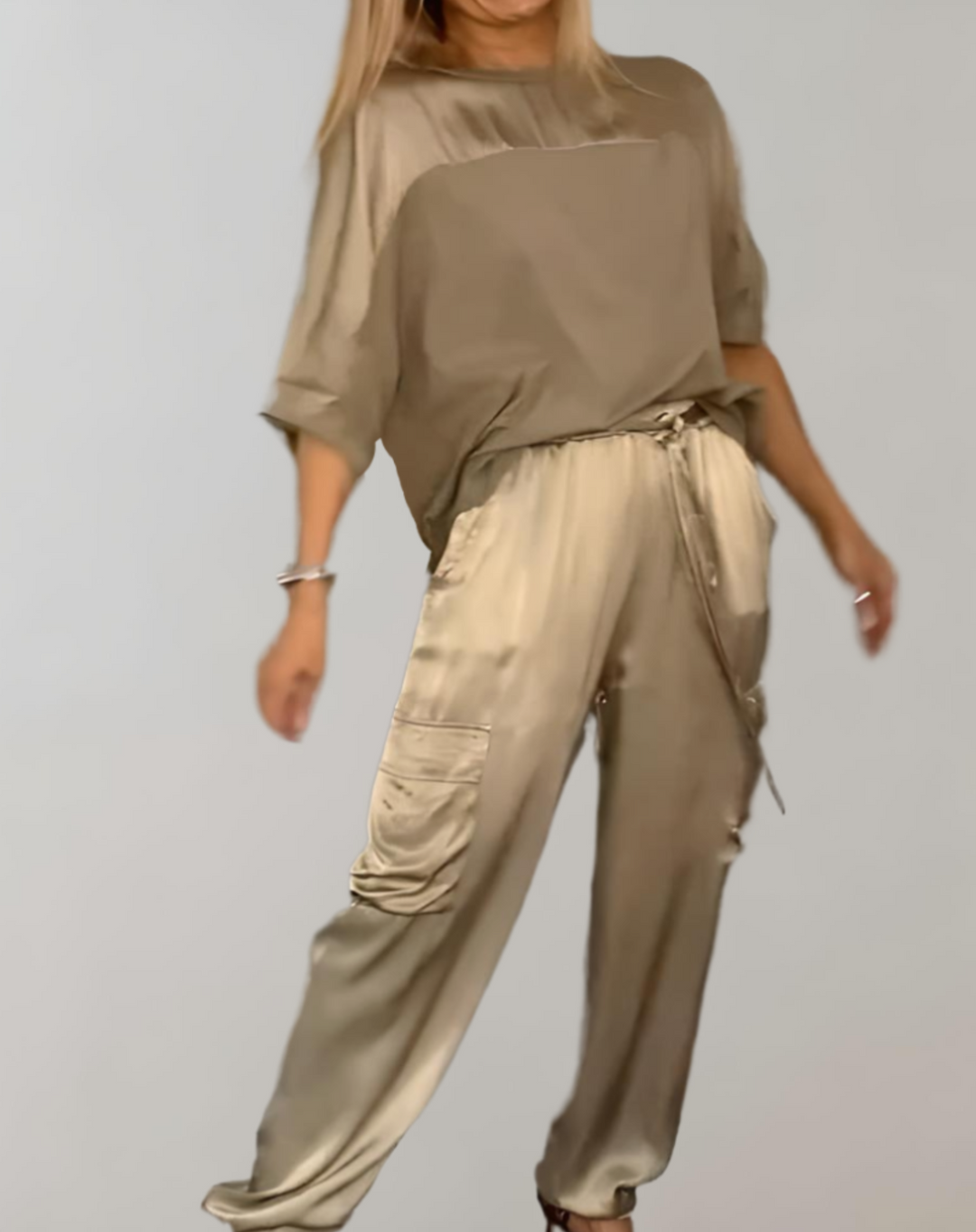 A woman wearing a silky-finish cargo top and pants lounge set with pockets.