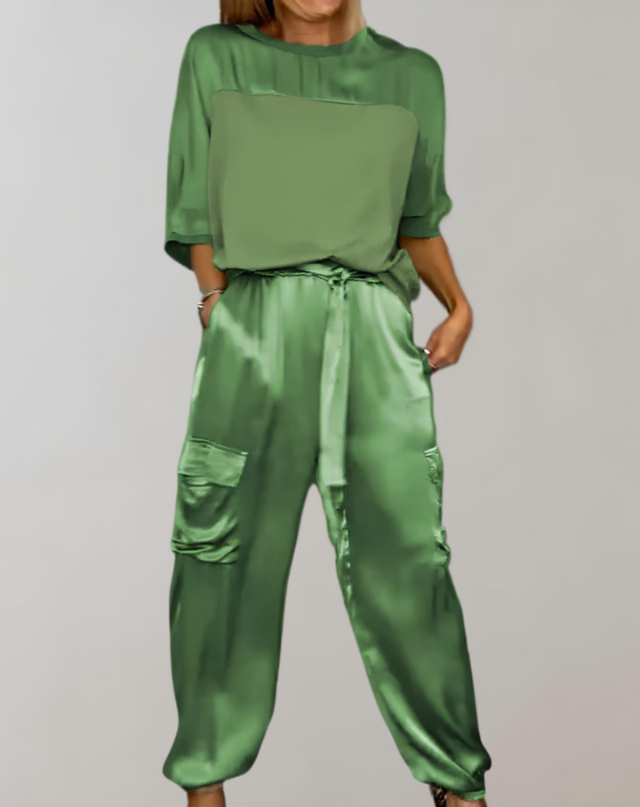 A woman wearing a silky-finish cargo top and pants lounge set with pockets.