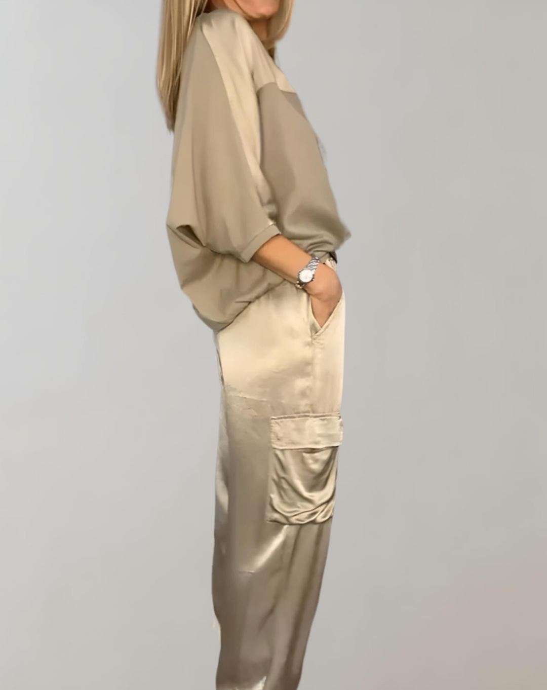 A woman wearing a silky-finish cargo top and pants lounge set with pockets.