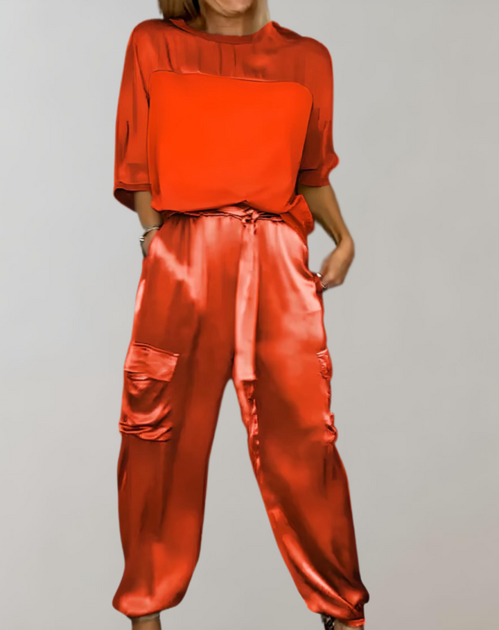 A woman wearing a silky-finish cargo top and pants lounge set with pockets.