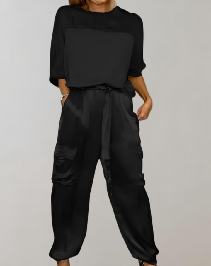 A woman wearing a silky-finish cargo top and pants lounge set with pockets.