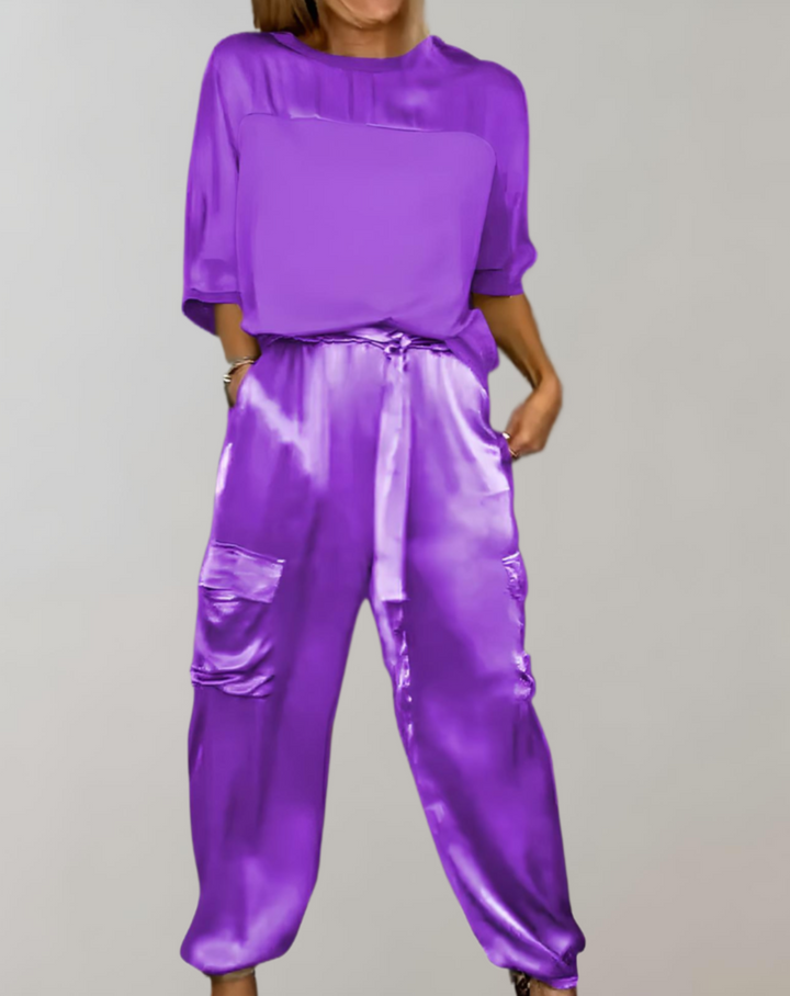 A woman wearing a silky-finish cargo top and pants lounge set with pockets.