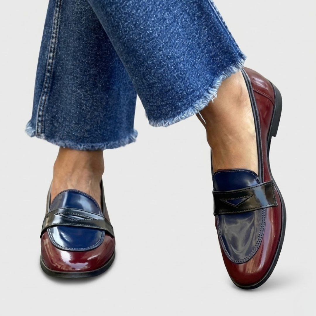 A woman wearing two-tone contrast loafers on a bright street.