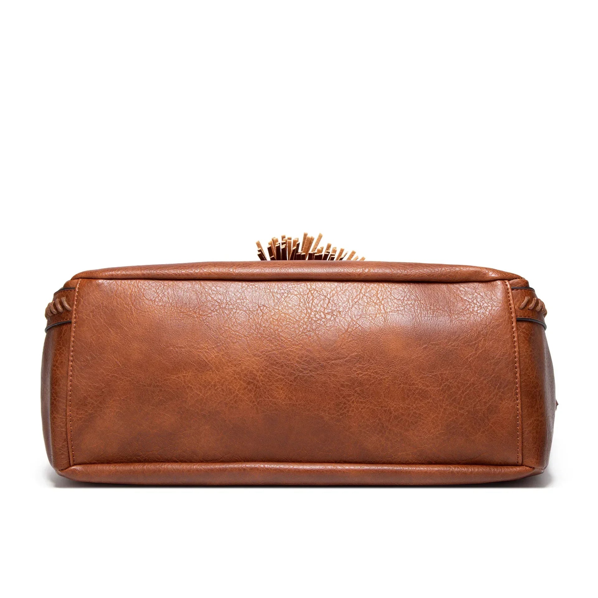 A woman carrying a soft tasselled shoulder bag while out for a walk in town.