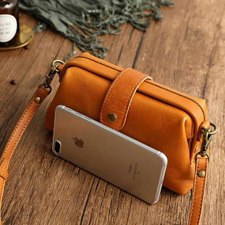 A woman carrying a trendy shoulder bag with a rich finish over one shoulder